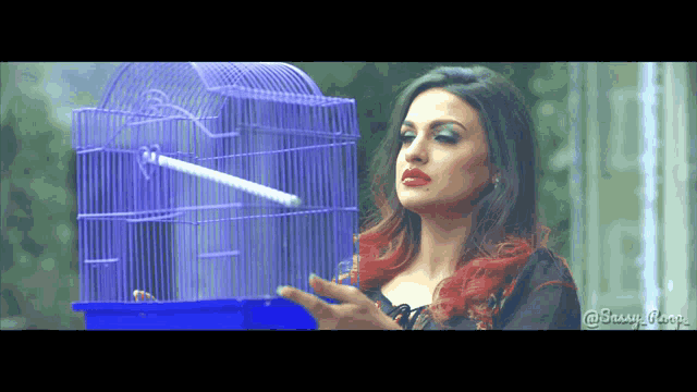 a woman holding a blue bird cage with the hashtag @snuy_girl