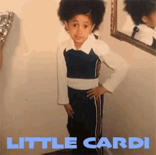 a little girl standing in front of a mirror with the words little cardi on the bottom right