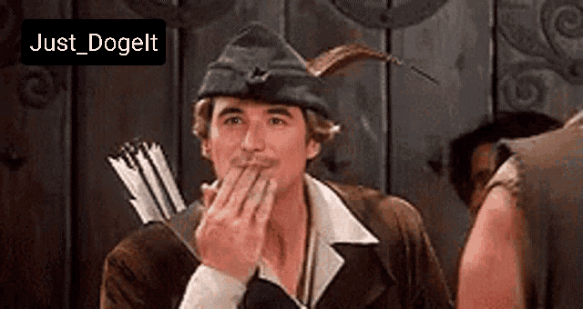 a man in a robin hood costume with a bow and arrow is covering his mouth with his hand .