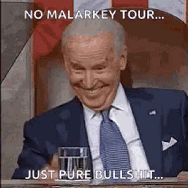 biden is smiling while holding a glass of water .