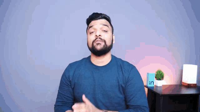 a man with a beard is wearing a blue shirt and talking