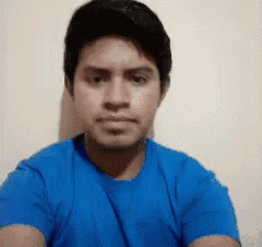 a man is wearing a blue shirt and looking at the camera