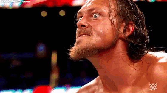 a man with a beard and a w logo on his chest looks up