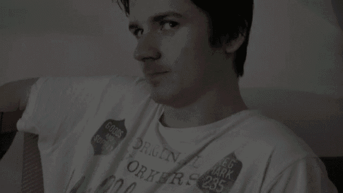 a man in a white shirt is smiling and looking at the camera .