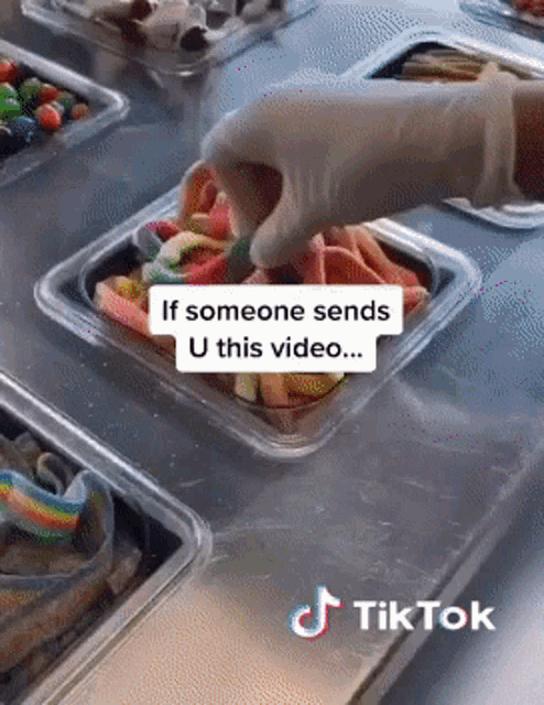 a person is putting gummy bears in a plastic container with a tiktok watermark