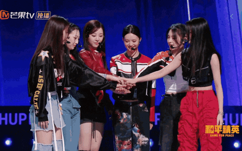 a group of women standing in a circle with one wearing a jacket that says " last year " on the sleeve