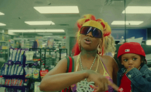 a woman wearing sunglasses and a necklace that says big sis
