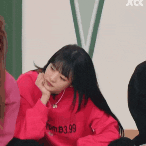 a girl wearing a red sweatshirt that says rom $ 3.99