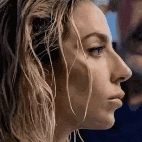 a close up of a woman 's face with wet hair looking to the side .