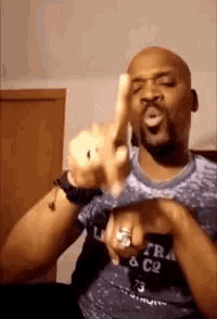 a man wearing a blue shirt is giving the middle finger