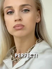 a woman wearing a white shirt and a silver chain necklace has the word perfect written on her face