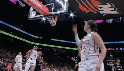 a basketball player with the number 5 on her jersey shoots the ball