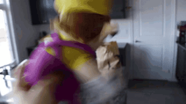 a person in a yellow and purple costume is holding a bag