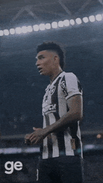 a soccer player is kneeling down in front of a crowd and the word ge is on the bottom right