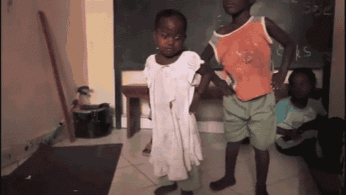 two children standing in front of a chalkboard that says ' ks ' on it