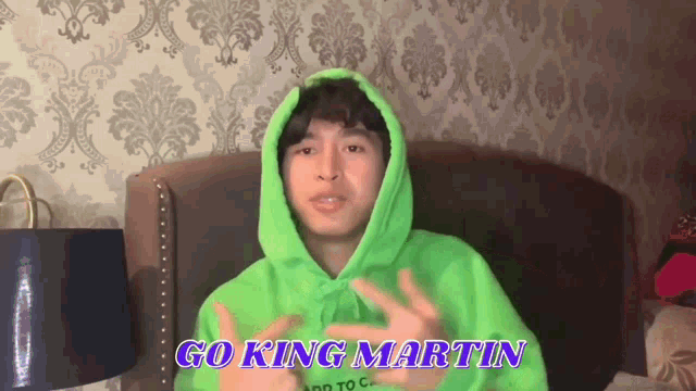 a man in a green hoodie with the words go king martin above him