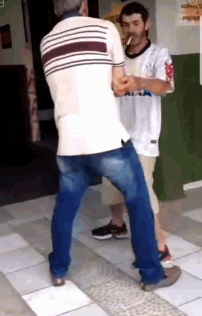 a man wearing a shirt that says ' caixa ' on it is standing next to another man