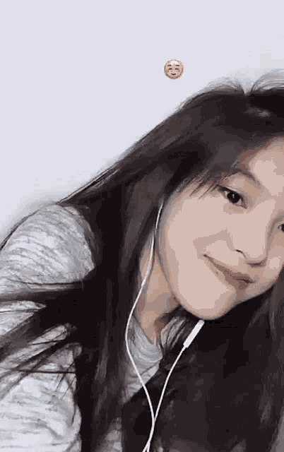 a girl wearing headphones is smiling and looking at the camera .