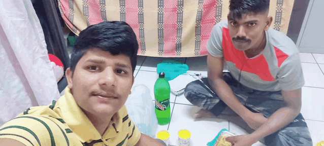 a bottle of mountain dew sits on the floor next to two boys