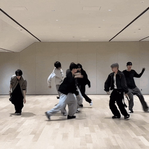 a group of young men are dancing in a room