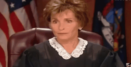 a woman in a judge 's robe is sitting in a courtroom .