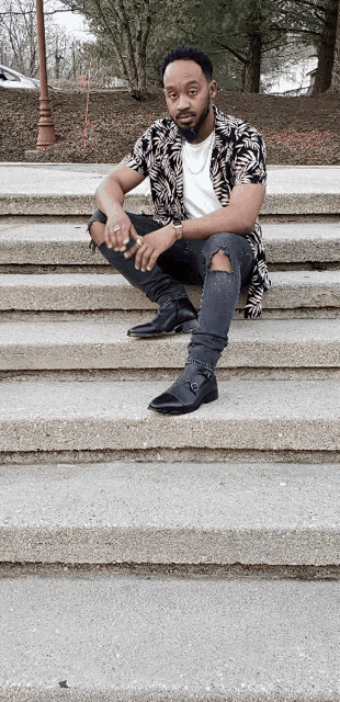 a man in a zebra print shirt sits on some steps