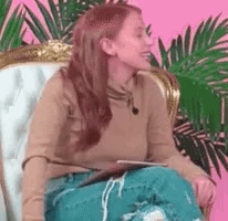 a woman is sitting in a chair with a tablet in her lap and a microphone in her ear .