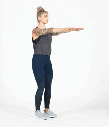 a woman with tattoos is doing squats with one leg up