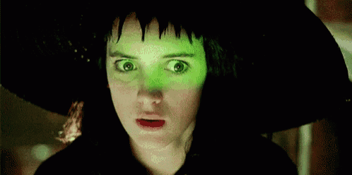 a close up of a woman wearing a black hat with green eyes .