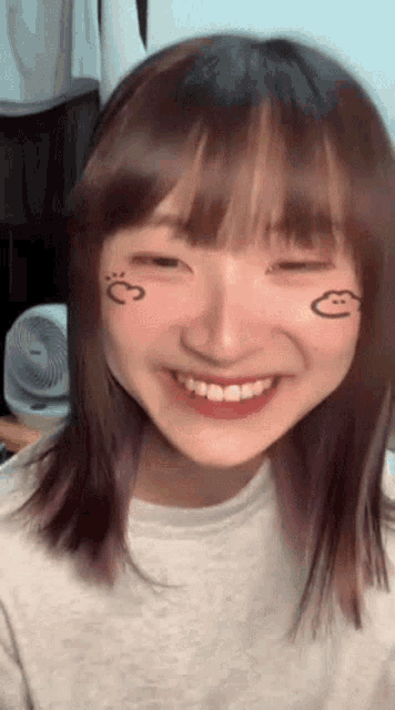 a girl with purple hair has a smiley face drawn on her face