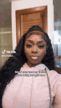 a woman is taking a selfie in front of a door and has a tiktok account