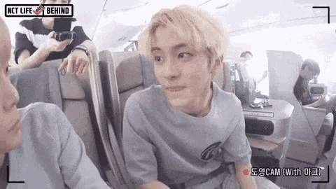 a man is sitting on a plane with a camera .