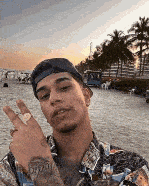 a man wearing a hat and a ring is standing on the beach