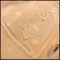 a heart in the sand with the words i love you written on it .