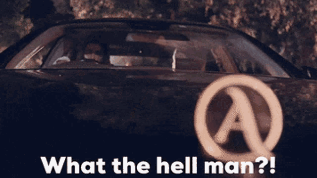 a man is driving a car with the words " what the hell man " on the bottom