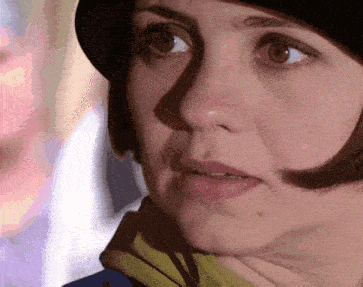 a close up of a woman 's face with a black hat on