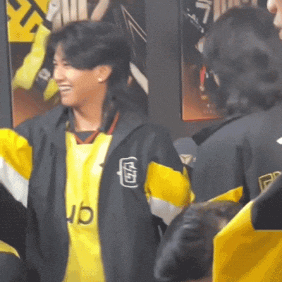 a woman wearing a yellow and black jacket with the word ub on it