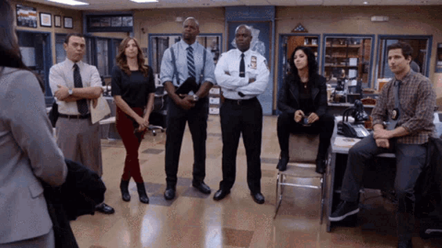 a group of police officers are standing in a room with a sign that says ' new york city police department ' on it