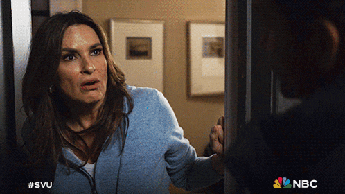 a woman is standing in a doorway with the nbc logo on the bottom right