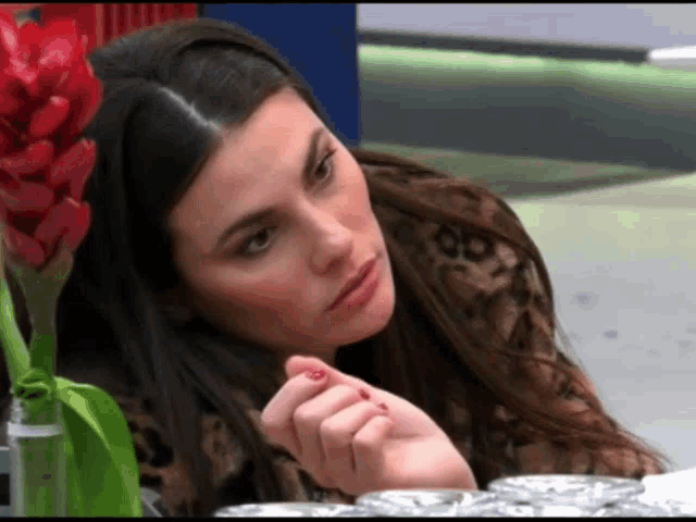a woman with red nail polish on her nails looks at something