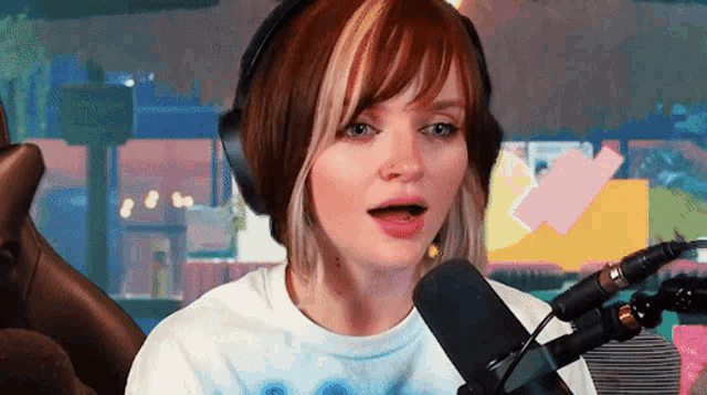 a woman wearing headphones is talking into a microphone .