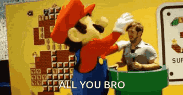 a man is standing next to a mario mascot who is saying all you bro .