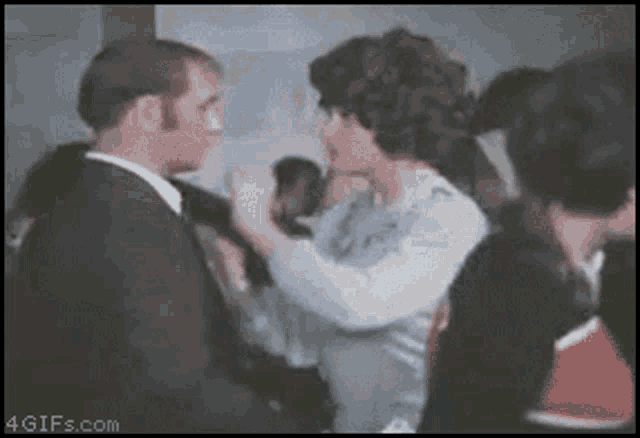 a man and a woman are dancing in front of a crowd of people and the website 4gifs.com is visible in the corner