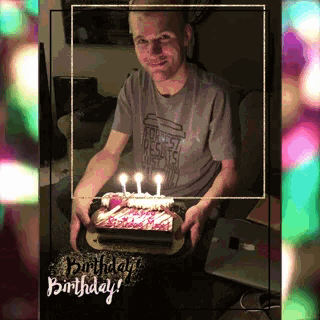 a man is holding a birthday cake with candles