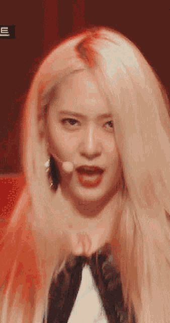 a close up of a blonde woman with a microphone