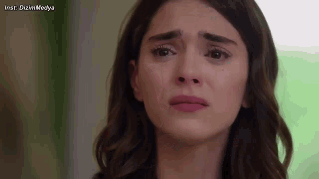 a close up of a woman 's face with a tear running down her face .
