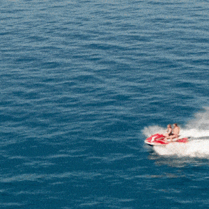 two people are riding a red and white jet ski in the ocean