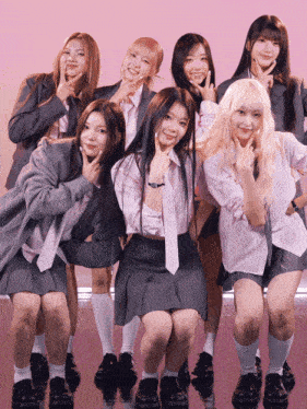 a group of girls posing for a picture with their hands in the air