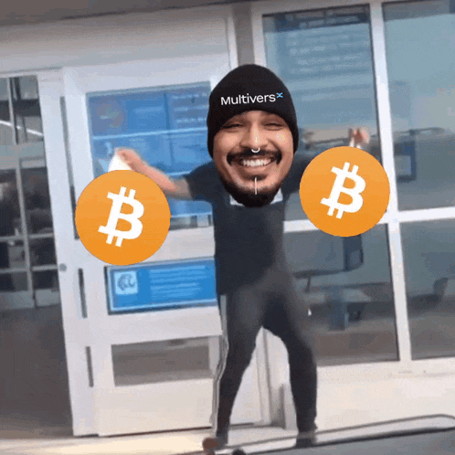 a man wearing a hat that says multiverse on it is holding two bitcoins