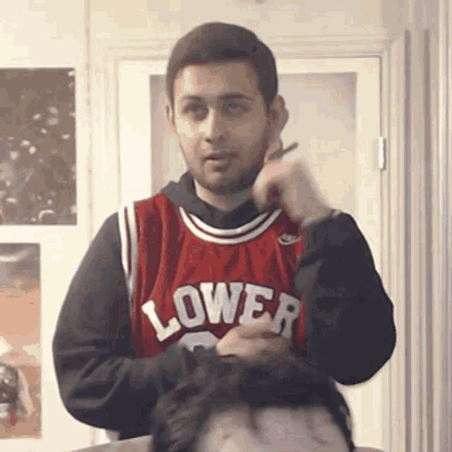a man wearing a red jersey that says lower on the front